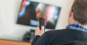 Man using remote while watching tv